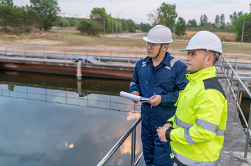 Fototapeta premium Environmental engineers work at wastewater treatment plants,Water supply engineering working at Water recycling plant for reuse,Technicians and engineers discuss work together.