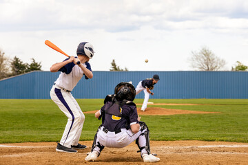 Baseball Player - Batter watching the pitched ball. Pitcher on the mound. Catcher ready at the...