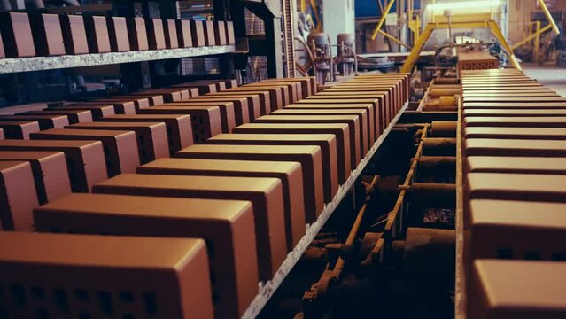 Brick production line. Fresh clay bricks being put on shelves for drying. 4k.