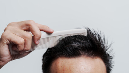 Naklejka premium Young confident asian chinese young man checking hair style and dandruff.