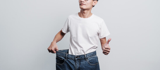 Young confident asian chinese weight loss man with oversize of jean pants.