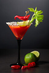 Bloody Mary cocktail with celery, lime, and red pepper.