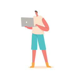 Young Smiling Man Standing With Laptop in Hands, Engrossed In Work, Diligently Tapping Away At The Keyboard