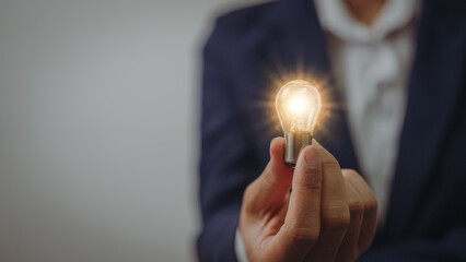 Business idea concept, Hands of business woman in suit holding light bulb with innovation and...