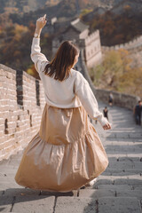 Obraz premium stylish girl visiting the Great Wall of China near Beijing during autumn season.