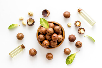 Bottles of macadamia nuts oil with raw nuts. Natural oil for cosmetic or cooking
