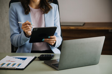 Financial analysts analyze business financial reports on a digital tablet planning investment...