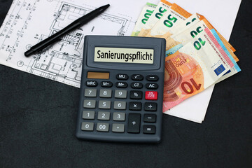 Geldscheine, Bauplan und Taschenrechner mit dem Wort Sanierungspflicht im Display.