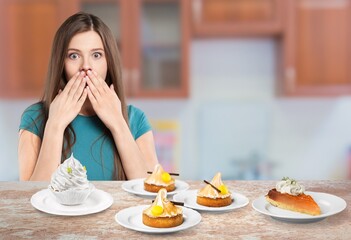 Funny young woman eating tasty sweet cake