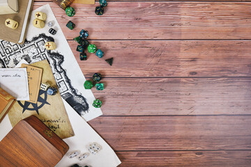 Tabletop role playing flat lay background with colorful RPG dices, rule books and notes on wooden background with copy space