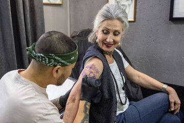 Trendy mature woman in the tattoo salon