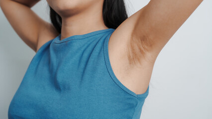 Young confident asian chinese female armpit with blue tank top isolated background.