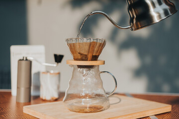 Making filtered drip coffee in coffee shop. Close up of brewing a drip hot espresso, pour over...