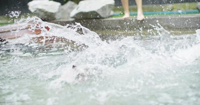 Playful black and white border collie fun play at swimming pool. Happy cute dog jump and dive to catch up toy into water. Summer activities, training sport exercise Family pet lifestyle. slow motion.