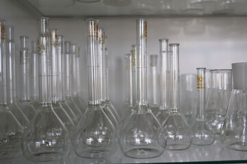 closeup photo set of glass flasks on a shelf in a chemical laboratory