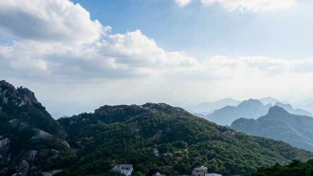 Time lapse video of the rocky Huangshan Mountain covered with trees on a sunny day, China