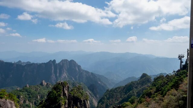 Time lapse video of the rocky Huangshan Mountain covered with trees on a sunny day, China