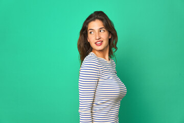 Young caucasian woman isolated looks aside smiling, cheerful and pleasant.