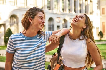 Two friends enjoy laughter and fun in a park.