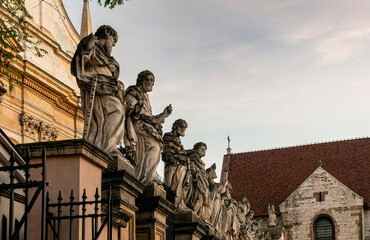 Fototapeta premium Beautiful gothic facade and statues of the catholic Church of the Holy Apostles Peter and Paul in the historical district of Krakow