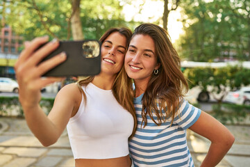 Naklejka premium Smiling friends taking a selfie in the park.