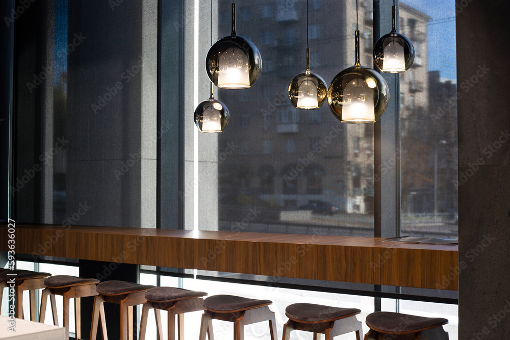 Aufkleber roller blinds in the cafe. solar shades black color in the urban style interior. wooden table near t