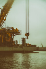 Statek dźwig do montażu instalacji wiatrowych na morzu w mglisty dzień.