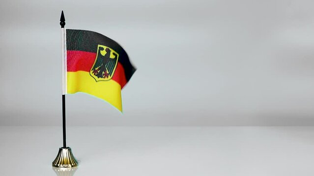 Government flag of Germany. The flag of germany flutters in the wind on a gray background.