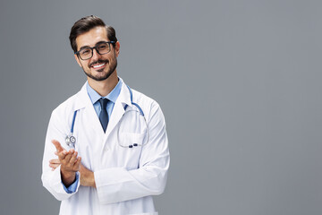 Male doctor in a white coat and glasses for vision and a stethoscope looks at the camera smile with teeth dentist on a gray isolated background, copy space, space for text, health