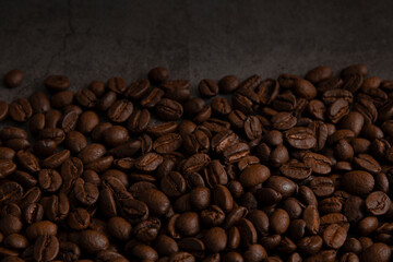 Roasted coffee beans on dark dark background.
