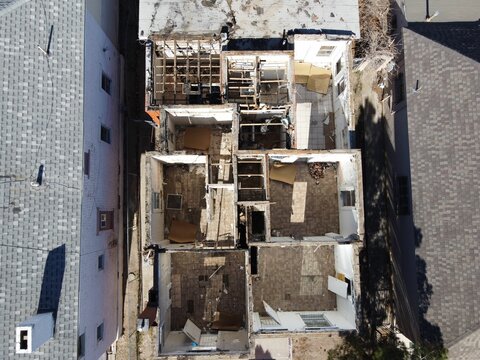 Aerial top view of a dilapidated house with no roof under the sun
