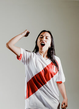 Photograph of Peruvian fan woman celebrating a goal of her team. Concept of people, emotions and sports.