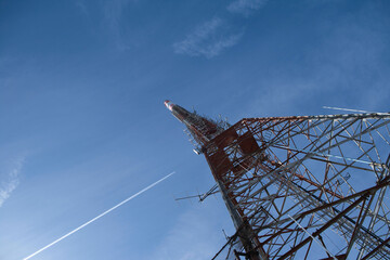 tv transmitter mast and airplane in the sky - obrazy, fototapety, plakaty