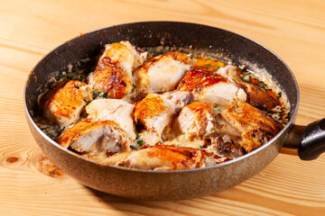 Shkmeruli, chicken in garlic sauce on a frying pan