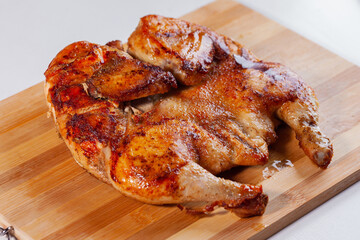 Fried chicken tabaka on a wooden board