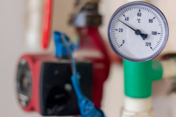 Detail of pressure gauge and temperature. Pump with a thermometer for a water underfloor heating system at home. Sensor and temperature control. Manometer, pipe, and valves of heating system