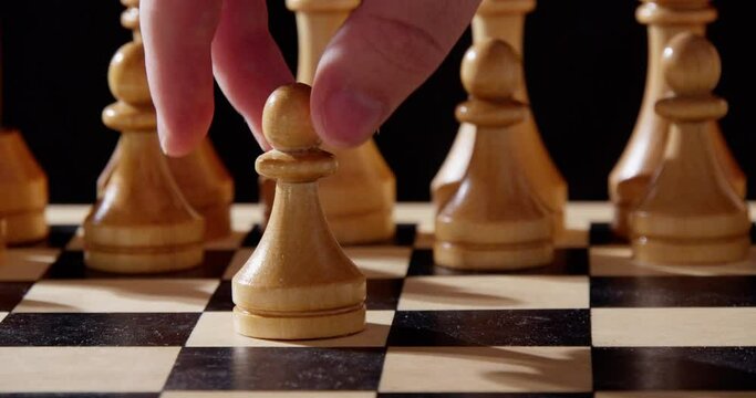 chess pieces on a chessboard. The first move. Wooden chess. Pawn forward. Close up shot