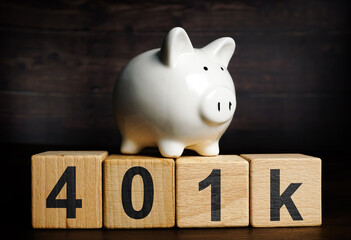Piggy bank on the wooden cubes with sign 401k. Retirement plan concept.