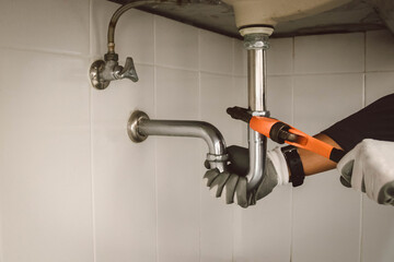 plumber at work in a bathroom, plumbing repair service , fix water plumbing leaks, replace the kitchen sink drain