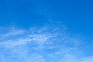 Looking straight up at the the sky. Thin clouds pattern with blue sky as background