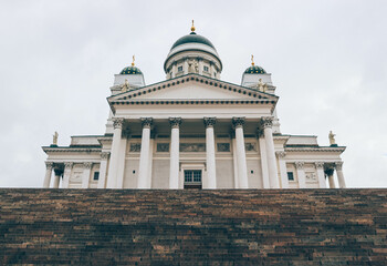 Minimalist look of lutheran finish cathedral over cloudy sky with green domes