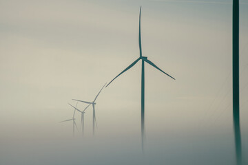 Windmills tops with rotor blades producing alternative form of energy for stations. Wind turbines...