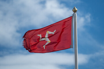 Isle of Man flag flying in the wind on a sunny day