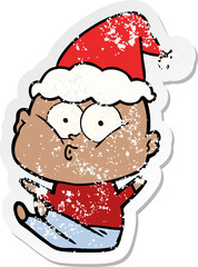 distressed sticker cartoon of a bald man staring wearing santa hat