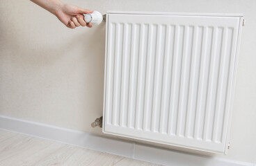 Adjustment of comfortable temperature on the wall radiator in the house. Saving energy resources, increasing the price of gas heating, industry. Copy space for text
