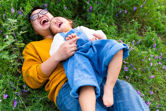 happy asian little girl with her father in the spring field