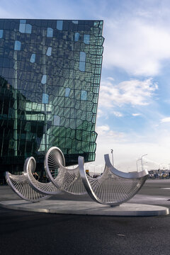 Reykjavik, Iceland: Harpa Concert Hall and Conference Centre with distinctive colored glass facade. Celestial sculpture (Himingl&aelig;va) by El&iacute;n Hansd&oacute;ttir celebrates the sound of the wind.
