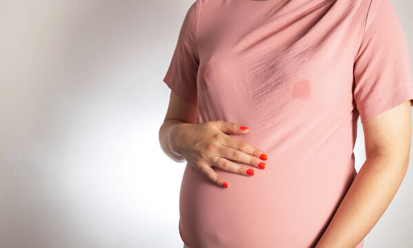 A soaked blouse from milk on the female breast of a nursing mother. Leak-proof bra pads, close-up. Copy space for text
