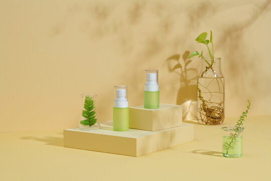 Cosmetic bottle containers with green herbal leaves and scienti