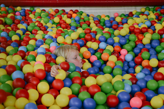 a kid playing in a ball pit